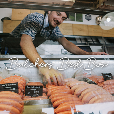 Waipawa Butcher Rhys Tamanui stands behind a glass cabinet filled with sausages, he is placing sausages in a row.