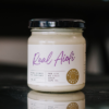 A jar of village press real aioli sits on a reflective bench space.