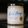 A jar of Village Press real mayo sits on a bench with a blurred background.