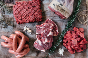 Overview shot of different mat products. Diced beef, sausages, steaks and a leg roast.