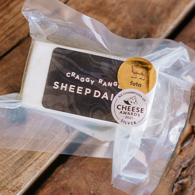 A wrapped packet of Craggy Range Sheep Dairy sits on a wooden board.