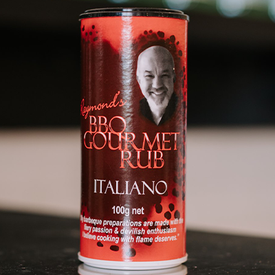 A shaker of Raymonds Rub Italiano flavour sits on a counter top with a blurrred background.